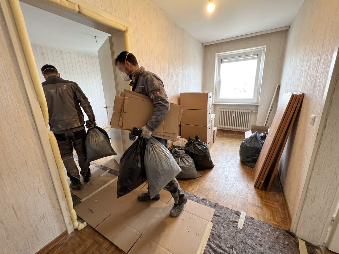 Räumung einer Messiwohnung in {Stadt}: Mitarbeiter tragen Säcke und Kartons aus der Wohnung